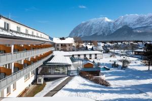 Vista árida de un edificio en la nieve con montañas en Hotel-Restaurant Grimmingblick, en Bad Mitterndorf