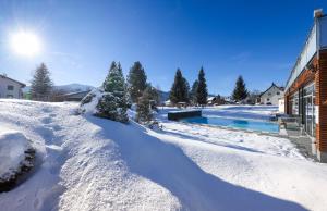 un patio cubierto de nieve con piscina en Hotel-Restaurant Grimmingblick, en Bad Mitterndorf