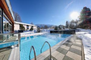 una piscina cubierta de nieve junto a una casa en Hotel-Restaurant Grimmingblick, en Bad Mitterndorf