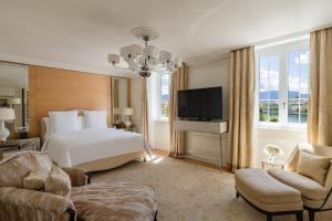 a hotel room with a bed and a television at Four Seasons Hotel des Bergues Geneva in Geneva