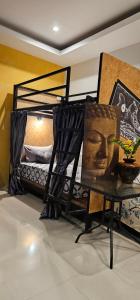 a room with a bed with a painting of a head at Eat n Sleep in Phuket Town