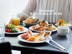 een tafel met borden en een persoon bij Mitsui Garden Hotel Shiodome Italia-gai - Tokyo in Tokyo