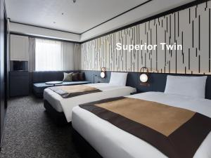 een hotelkamer met 2 bedden en een bank bij Mitsui Garden Hotel Shiodome Italia-gai - Tokyo in Tokyo