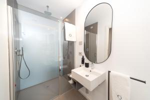 a white bathroom with a sink and a mirror at Open Hotel in Rimini