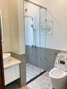 e bagno con doccia, servizi igienici e lavandino. di NHỚ House V a Da Lat