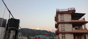 wysoki budynek z górą w tle w obiekcie Pokhara Metro Eco Hotel w mieście Pokhara