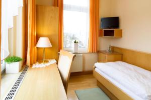 una piccola camera con letto e finestra di Hotel Heinz a Plauen