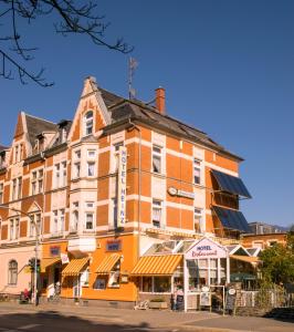 un grande edificio arancione all'angolo di una strada di Hotel Heinz a Plauen