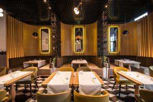 a restaurant dining room with tables and chairs at Hotel Platinia in Cluj-Napoca