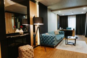 a living room with a blue couch and a table at Hotel Platinia in Cluj-Napoca