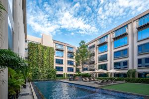 an exterior view of a building with a swimming pool at Hyatt Centric Candolim Goa in Calangute