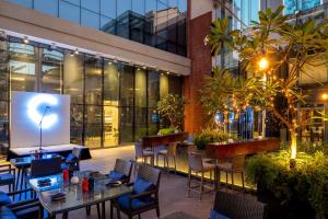 a restaurant with tables and chairs and a building at Hyatt Centric Candolim Goa in Calangute