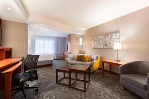 a hotel room with a bed and a desk at Courtyard by Marriott Kalamazoo Portage in Portage