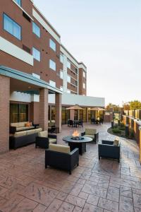 a patio with couches and tables and a building at Courtyard by Marriott Kalamazoo Portage in Portage