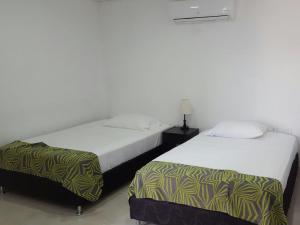 2 Betten nebeneinander in einem Zimmer in der Unterkunft Hotel Septima Avenida in Neiva