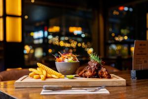 una mesa de madera con un plato de comida y maíz en The Vira Bali Boutique Hotel & Suite, en Kuta