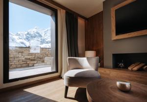 ブレウイル・チェルヴィナイアにあるValtur Cervinia Cristallo Ski Resortのリビングルーム(椅子、大きな窓付)