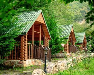 a row of small wooden houses in a garden at Rainforest Resort and Spa, Igatpuri -Nature's Luxury Awaits in Igatpuri