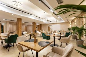 ein Restaurant mit Holztischen und grünen Stühlen in der Unterkunft AMAR Design Hotel by HMG in Sofia