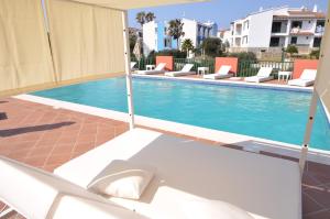 basen z leżakami obok budynku w obiekcie Sant Joan Apartaments - Adults Only w mieście Cala en Blanes