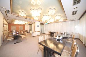 une salle à manger avec des tables, des chaises et des lustres dans l'établissement Hotel Il Viale Hachinohe, à Hachinohe