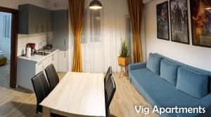 een woonkamer met een blauwe bank en een tafel bij Vig Apartments in Timişoara