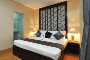 a bedroom with a large bed with a large headboard at 717 Cesar Place Hotel in Tagbilaran City