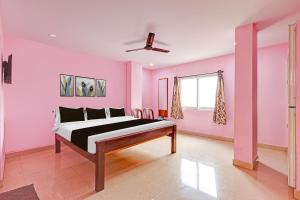 una camera rosa con un letto di Super Hotel O Daba Gardens Near Dolphin Junction a Alipur