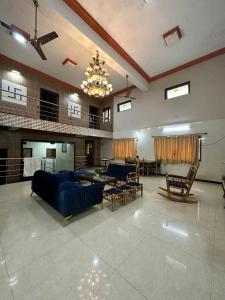 a large living room with blue furniture and a chandelier at Airspace villa in Igatpuri