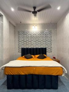 a bedroom with a large bed with a ceiling fan at Airspace villa in Igatpuri