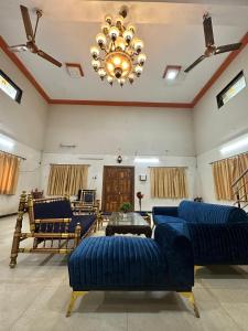 a living room with blue couches and a chandelier at Airspace villa in Igatpuri