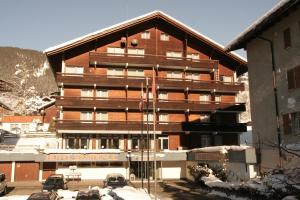 ein großes Gebäude mit davor geparkt in der Unterkunft Hotel Residence in Grindelwald