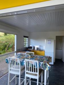 een keuken met een tafel en 2 witte stoelen bij Le domaine de Périolat in Le François