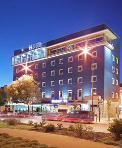 a building with cars parked in front of it at Luna Esperanca Centro Hotel in Setúbal