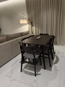 mesa de comedor con sillas y sofá en Sunrise Luxury Two Bedroom Apartment, en Al Khobar