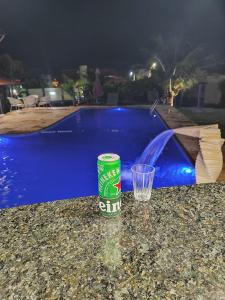 een fles en een glas op een tafel naast een zwembad bij Pousada Vila Italia - Porto da Dunas in Aquiraz