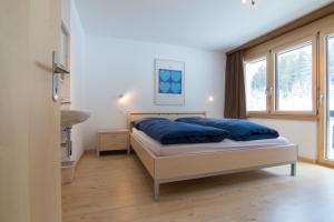 a bedroom with a bed with blue pillows on it at Mischi 5 in Saas-Fee