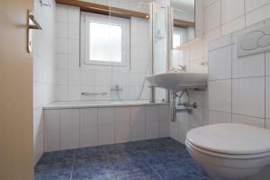 a white bathroom with a toilet and a sink at Mischi 5 in Saas-Fee