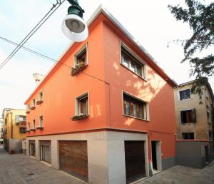 um edifício laranja com uma luz de rua em frente em B&B Rialto Dream em Veneza