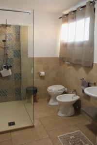 a bathroom with a toilet and a sink and a shower at Casa Giuliani in Porto Cesareo