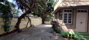 eine Garage mit einer weißen Tür und einem Baum in der Unterkunft Madhav Bhavan Guest House in Pune