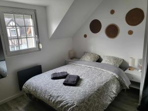 een slaapkamer met een bed met twee handdoeken erop bij "O'Dbark" - duplex 2 étoiles - à 100m de la plage in Courseulles-sur-Mer