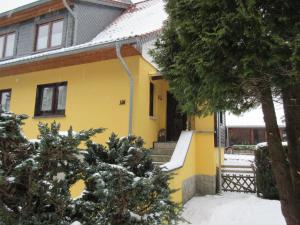 a yellow house with snow in front of it at Ferienhaus Schulze in Schierke