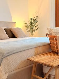 een slaapkamer met een bed met een houten bank bij Epidavros View Villas in Oud Epidauros