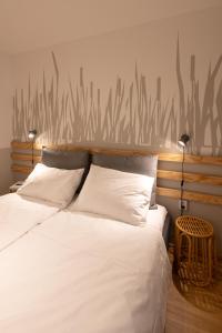 a bedroom with two beds with white sheets and tall grass on the wall at HausPension in Vienna