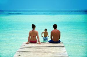 a group of three people sitting on a dock in the water at Grand Oasis Palm - All inclusive in Cancún