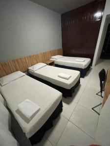 ein Zimmer mit 2 Betten und einem Stuhl darin in der Unterkunft CR Hotel Bueno in Goiânia