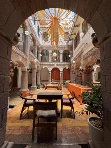 Habitación grande con mesas y sillas en un edificio en Waman Qorikancha, en Cusco