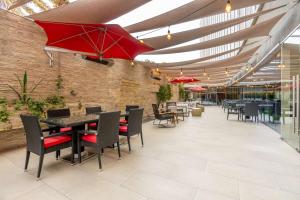 a restaurant with tables and chairs and a red umbrella at Hilton Garden Inn Iquique in Iquique