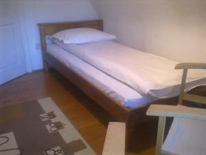 1 dormitorio con 1 cama con sábanas blancas y mesa en Casa Gabriela, en Sinaia